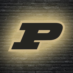May include: A black letter "P" with a gold outline, set against a dark brick wall background. The letter is illuminated with a soft, golden glow, creating a subtle highlight effect. The image has a collegiate or university theme.