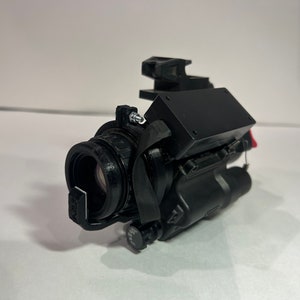 May include: A black night vision scope with a lens cover and a black attachment on top.