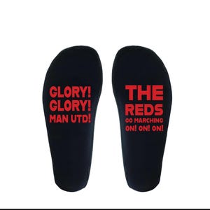 May include: Two black insoles with red text. One says "GLORY! GLORY! MAN UTD!" and the other says "THE REDS GO MARCHING ON! ON! ON!" for a football fan.