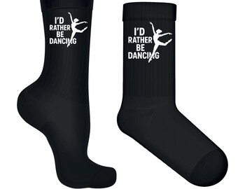 May include: Two black socks with the text "I'd Rather Be Dancing" and a ballerina graphic in white. The socks are crew length and made of a soft material. Perfect for dancers or anyone who loves to dance.