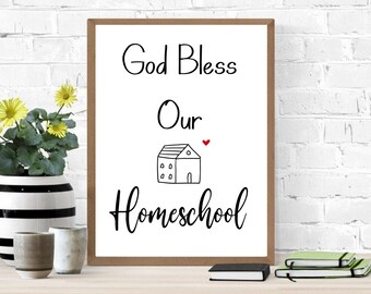 May include: A white framed print with black text that reads "God Bless Our Homeschool" with a small house illustration and a red heart above it.