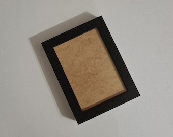 May include: A black picture frame with a brown mat.