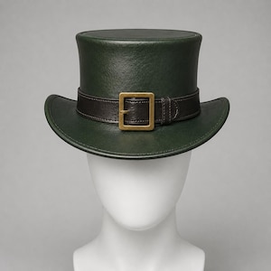 May include: A dark forest green top hat featuring a smooth, structured finish. A dark brown leather band encircles the base of the crown, secured by a rectangular, antique brass-toned metal buckle centered at the front of the hat.