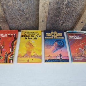 May include: Four vintage science fiction paperback books with colorful covers. The titles are "Star Science Fiction No. 6", "October the First Is Too Late", "A.E. Van Vogt The Voyage of the Space Beagle", and "Seeds of Change".