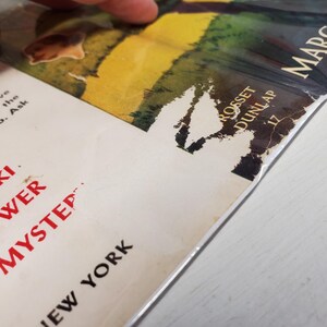 May include: Close-up of a vintage book cover with the title "Vicki Answer Mystery" in red letters. The cover features a colorful illustration and the author's name, Margaret, is visible. The book is slightly damaged.