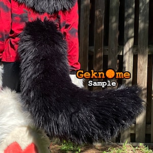 May include: A long, black faux fur tail, likely for a costume or cosplay. The tail is thick and fluffy, with a slight curve. The text "Geknome Sample" is visible in the image.