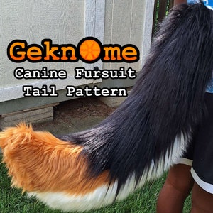 May include: A canine fursuit tail pattern with the text "Geknome Canine Fursuit Tail Pattern". The tail is black, white, and orange, with long, fluffy fur. The tail is held up against a light-coloured wooden structure.