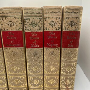 May include: A set of five books with gold-embossed spines and red labels. The labels read "The Works of Shakespeare", "The Works of Wilde", "The Works of Kipling", and "The Works of Poe".