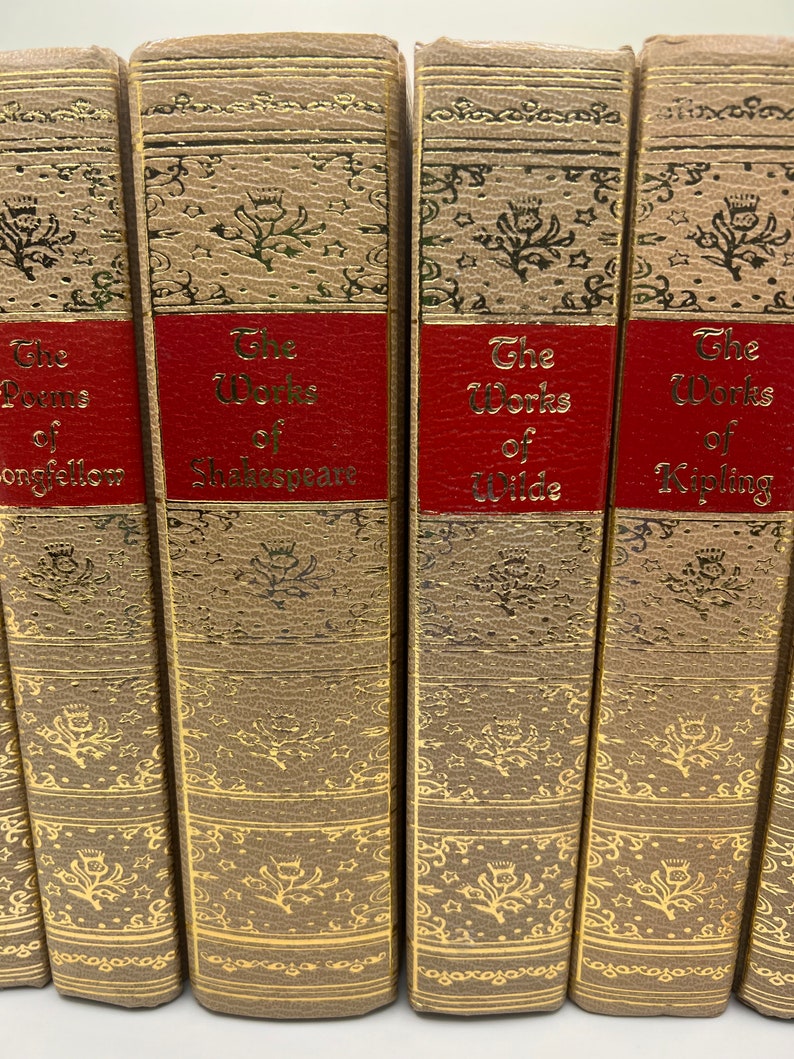 May include: A set of five brown hardcover books with gold accents and red spines. The titles on the spines are "The Poems of Longfellow", "The Works of Shakespeare", "The Works of Wilde", "The Works of Kipling", and "The Works of Poe".