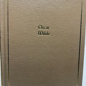 May include: A brown leather-bound book with gold lettering on the front cover that reads "Oscar Wilde".