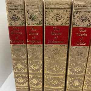 May include: A set of five vintage hardcover books with gold accents and red spines. The titles are "The Poems of Browning", "The Poems of Longfellow", "The Works of Shakespeare", and "The Works of Wilde".