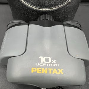 Vintage Pentax 10x UCF mini binoculars compact light gray and black protective case included.  Works great questions welcome.