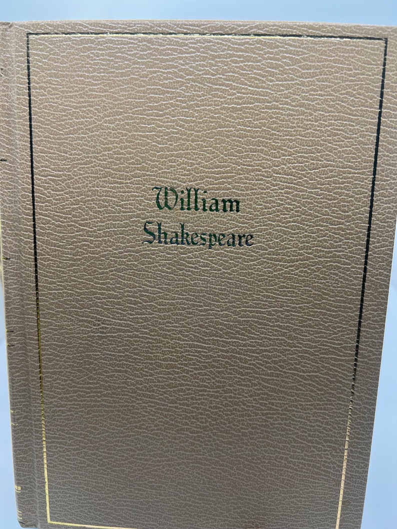 May include: A brown leather-bound book with a gold border and the text "William Shakespeare" embossed in green on the front cover.