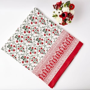 Può includere: Tovaglia bianca con un motivo floreale rosso e un bordo rosso. La tovaglia ha un design tradizionale di stampa a blocchi indiano.