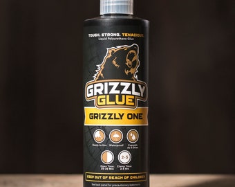 May include: A black bottle of Grizzly Glue Grizzly One liquid polyurethane glue. The bottle has a bear logo and the text "Tough. Strong. Tenacious." The bottle is 16 ounces and has a warning to keep out of reach of children.