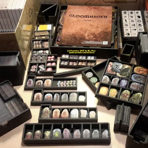 Puede incluir: Un organizador de juego de espuma negra para el juego de mesa Gloomhaven. El organizador está diseñado para contener todos los componentes del juego, incluidas las cartas, las fichas y las miniaturas. El organizador está diseñado para caber dentro de la caja del juego.