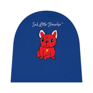 May include: Blue beanie featuring a red cartoon French bulldog wearing a lightning bolt on its chest. The text "Sad Little Frenchie™" is above the bulldog.