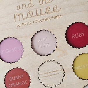 May include: Wooden acrylic color chart with the text "bobo and the mouse". The chart features various color samples, including Blossom, Rose Petal, Ruby, Burnt Orange, and Mustard. The website address is also visible.
