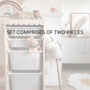 May include: A white wooden storage unit with three drawers, featuring a scalloped edge on the top. The unit is filled with toys, including a pink doll and a white unicorn rocking horse. The text "SET COMPRISES OF TWO PIECES" is displayed on the front of the unit.