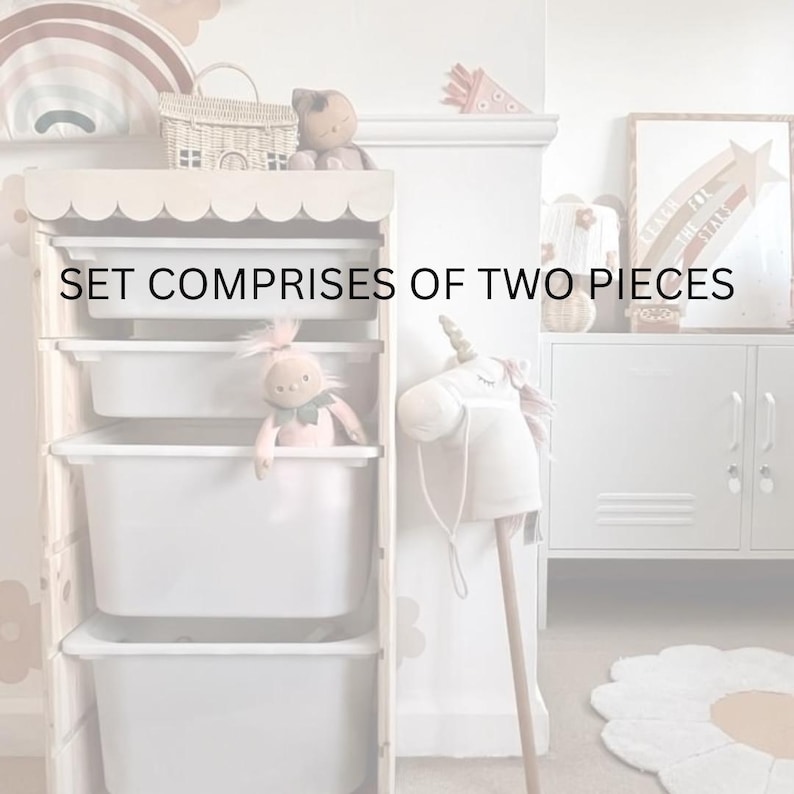 May include: A white wooden storage unit with three drawers, featuring a scalloped edge on the top. The unit is filled with toys, including a pink doll and a white unicorn rocking horse. The text "SET COMPRISES OF TWO PIECES" is displayed on the front of the unit.