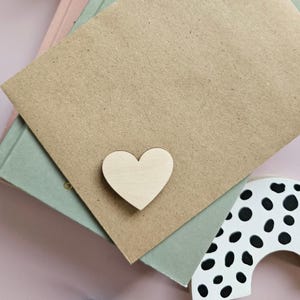 May include: A light brown wooden heart shape on a brown paper background.