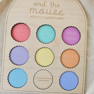 May include: Wooden acrylic color chart by Bobo and the Mouse. The chart features nine scalloped circles with various colors and names, including Raspberry Sherbert, Spearmint Green, and Bubblegum Blue. The brand name is at the top.