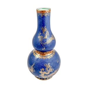 May include: A blue and gold ceramic vase with a gourd shape and a dragon design. The vase has a narrow neck and a wide base.