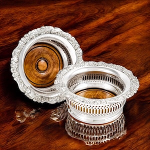 Antique Victorian silver plated magnum-sized pair of bottle coasters, Rococo Revival style floral borders, ornate English tableware, c 1880s