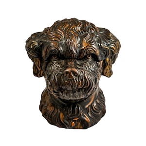 May include: A dark brown ceramic dog head sculpture with a textured fur design. The dog has a serious expression with its mouth closed and its eyes looking forward.