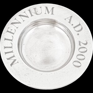 May include: A silver plate with the inscription "MILLENNIUM A.D. 2000" around the rim.