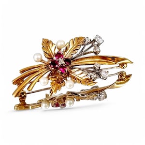Puede incluir: Un broche de oro y plata con un diseño floral. El broche presenta rubíes rojos, perlas blancas y diamantes.
