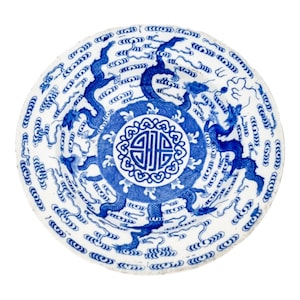 May include: A white ceramic plate with a blue and white design of dragons and clouds. The center of the plate features a blue and white circular design with a Chinese symbol.