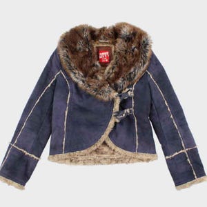 Peut inclure: Veste bleu marine avec col et doublure en fausse fourrure. La veste a une texture semblable à du daim avec des bordures marron clair et une fermeture à bascule. L'étiquette sur la veste indique "Miss Sixty".