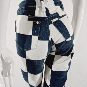May include: Black and white checkered jeans with a high waist and a straight leg fit.