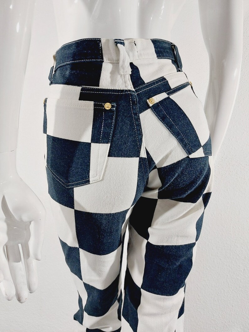 May include: Black and white checkered jeans with a high waist and a straight leg fit.