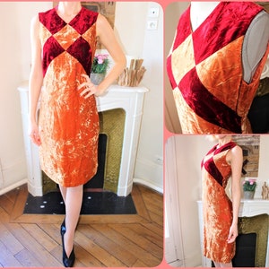 May include: A sleeveless dress with a geometric pattern of red and orange velvet. The dress is fitted and has a straight skirt.
