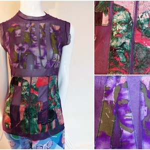 Puede incluir: Top morado sin mangas de malla con un estampado gráfico de caras y la palabra "FAKE" en letras grandes.