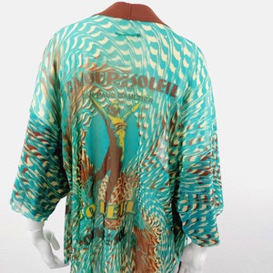 May include: A turquoise and brown patterned sheer kimono with a brown collar and the text "Amour Soleil Jean Paul Gaultier" printed on the back.