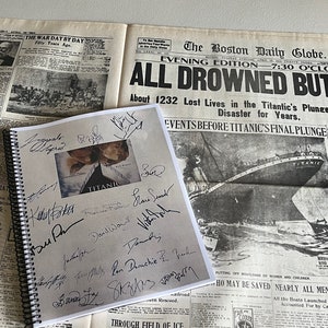 May include: A close-up of a brown leather-bound notebook with a black spiral binding. The notebook has a black and white photo of the Titanic on the cover with the word "TITANIC" printed in white. The notebook is covered in signatures from various people. The notebook is sitting on top of a newspaper with the headline "ALL DROWNED BUT 868" printed in black.