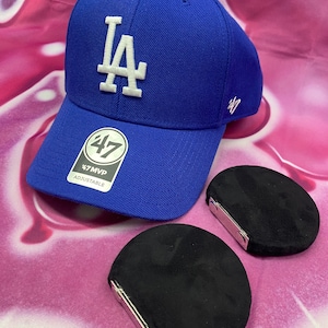 May include: A blue baseball cap with a white "LA" logo and a white "47 MVP" label. The cap is adjustable and comes with two black velvet hat shapers.