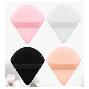May include: Four diamond-shaped makeup sponges in pink, white, black, and peach colors. Each sponge has a black elastic band around the top.