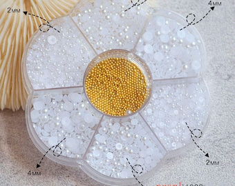 Pode incluir: Um recipiente de plástico transparente em forma de flor com sete compartimentos cheios de contas de pérola brancas de diferentes tamanhos. O recipiente tem etiquetas que indicam o tamanho das contas em milímetros: 2 mm, 3 mm e 4 mm. O texto "pearl 1000 beads 400" está impresso no recipiente.