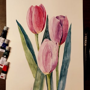 May include: Watercolor painting of three tulips in shades of pink and purple, with green leaves. The artwork is on white paper, with tubes of watercolor paint and paintbrushes visible. The painting is signed and dated.