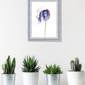 May include: A framed watercolor print of a blue and purple flower with orange accents. The artwork is in a light blue frame and hangs on a white wall above four potted plants: a cactus, a succulent, and two other green plants.