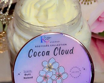 May include: A jar of body butter with a light yellow, whipped texture. The lid features the text "Cocoa Cloud" and "Triple Body Butter Blend!" with a floral design. The jar contains 8.5 oz (241 g) of product.