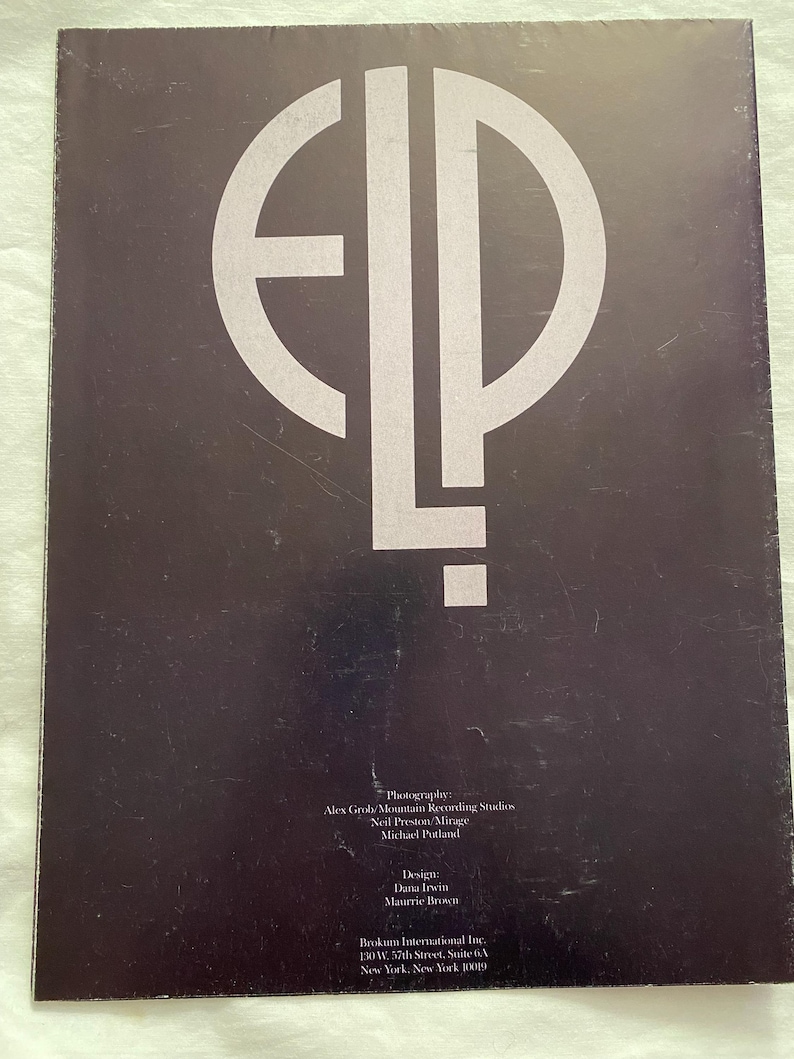 May include: A dark brown album cover featuring a large, stylized white "ELP" logo. The cover includes text with photography and design credits, along with the address of Brokum International Inc. in New York.