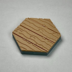 May include: A hexagonal wooden tile with a light brown woodgrain pattern. The tile has a blue border.