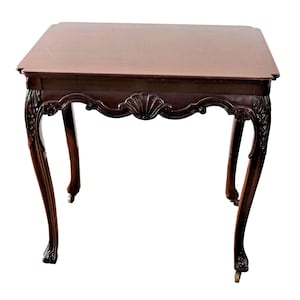 Op de afbeelding: Een donkerbruine houten tafel met sierlijke gegraveerde poten en een glad tafelblad. De tafel heeft een klassiek ontwerp en is perfect voor een woonkamer of eetkamer.