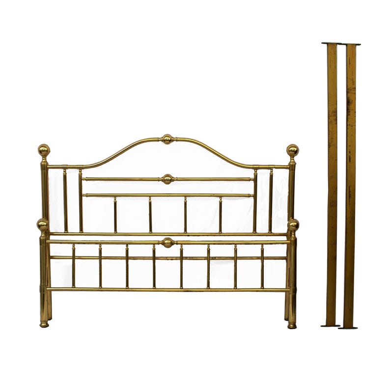 May include: A gold-colored metal bed frame with a curved headboard and footboard. The frame has a classic design with vertical and horizontal bars, and decorative ball finials. Two matching posts stand to the right of the frame.
