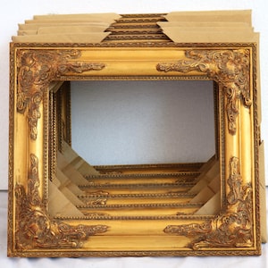 K&ouml;nnte beinhalten: Ein Stapel verzierter goldener Bilderrahmen mit komplizierten Details. Die Rahmen sind aus Holz und haben eine gl&auml;nzende Oberfl&auml;che.